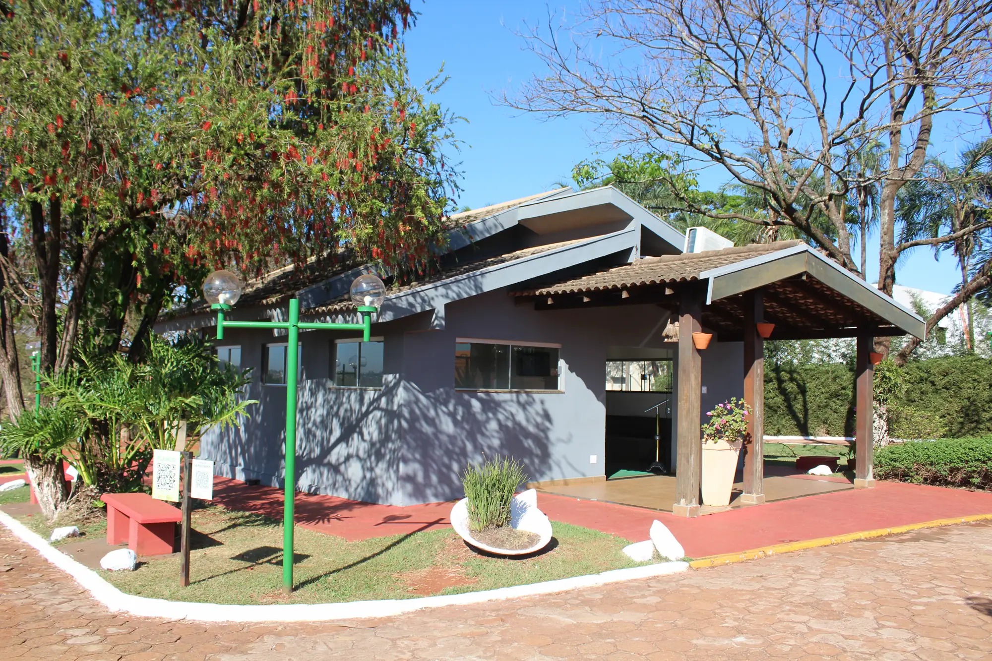Capela do Memorial Jardim das Oliveiras cercada por jardim e árvores